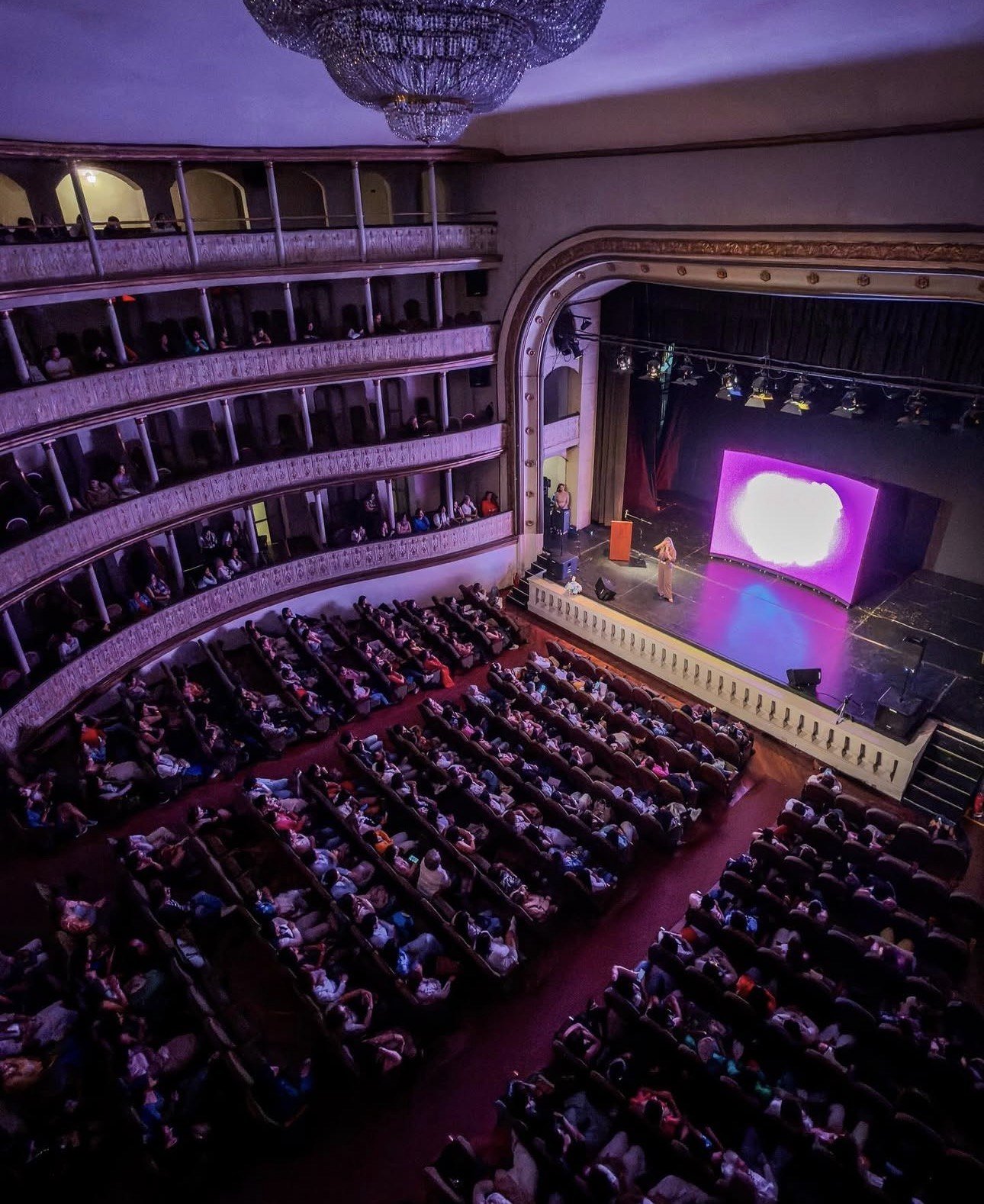 Vista general de una conferencia de Mariajo Mafla en un teatro con público